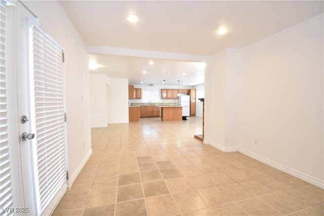 unfurnished living room featuring light tile patterned floors, baseboards, and recessed lighting