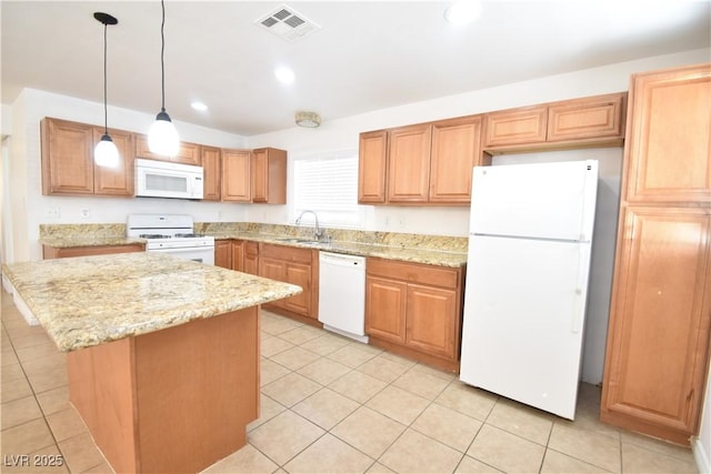 kitchen with white appliances, visible vents, light stone counters, a center island, and a sink