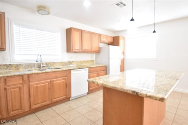 kitchen with light stone counters, white appliances, a sink, visible vents, and hanging light fixtures