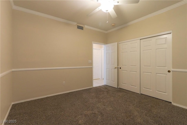 unfurnished bedroom featuring baseboards, visible vents, crown molding, carpet flooring, and a closet