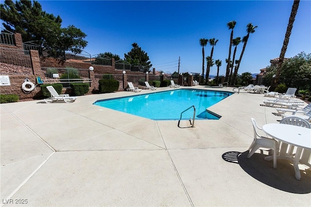 community pool featuring fence and a patio