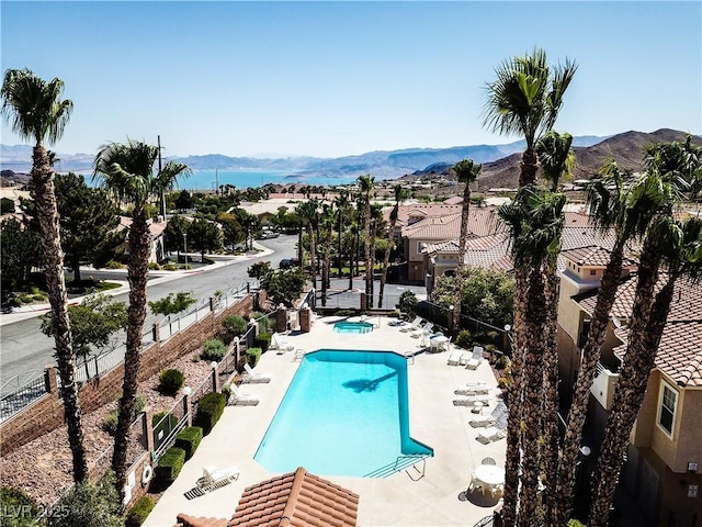 pool featuring a patio area, a fenced backyard, and a mountain view