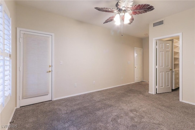 carpeted spare room featuring visible vents, ceiling fan, and baseboards