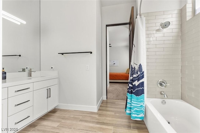 full bath with shower / bath combo, wood finished floors, vanity, and baseboards