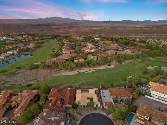 aerial view at dusk with a residential view, golf course view, and a water and mountain view