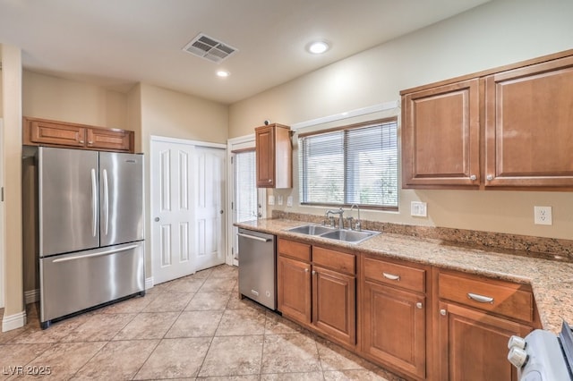 1332 Cedar Berry Ct, Henderson, NV 89012 - kitchen featuring stainless steel appliances, a sink, brown cabinets, recessed lighting, and light tile patterned floors