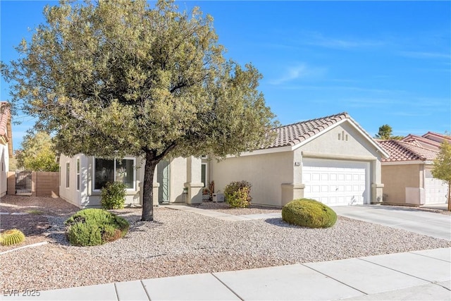 view of front of home with driveway, a tiled roof, an attached garage, fence, and stucco siding