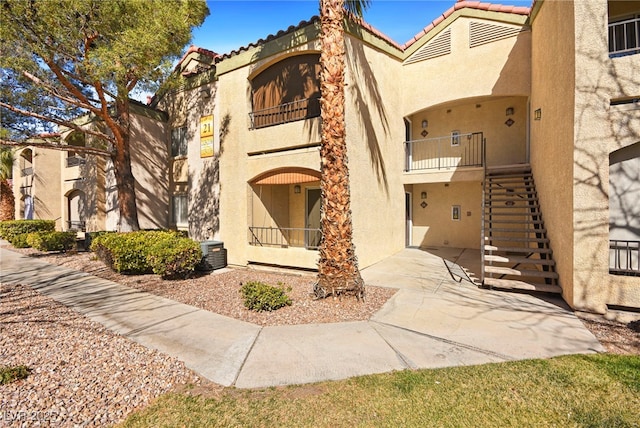 view of property featuring stairs and central AC