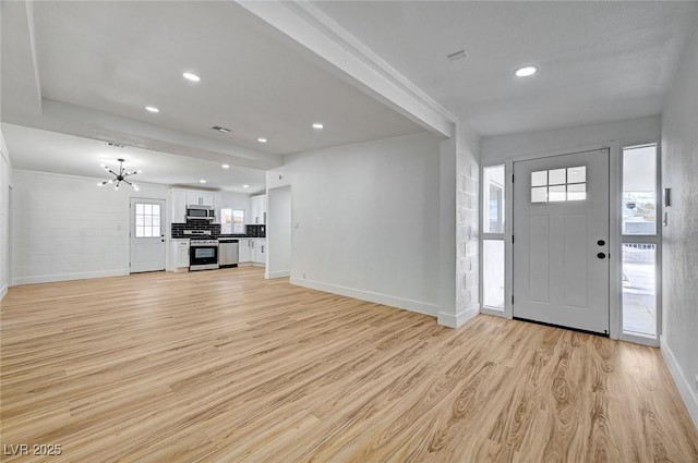 entryway with baseboards, recessed lighting, light wood-style flooring, and an inviting chandelier