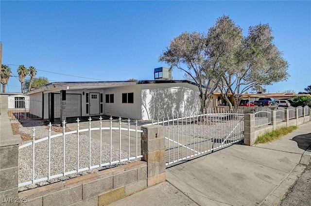 view of front of property with a garage, driveway, and a fenced front yard