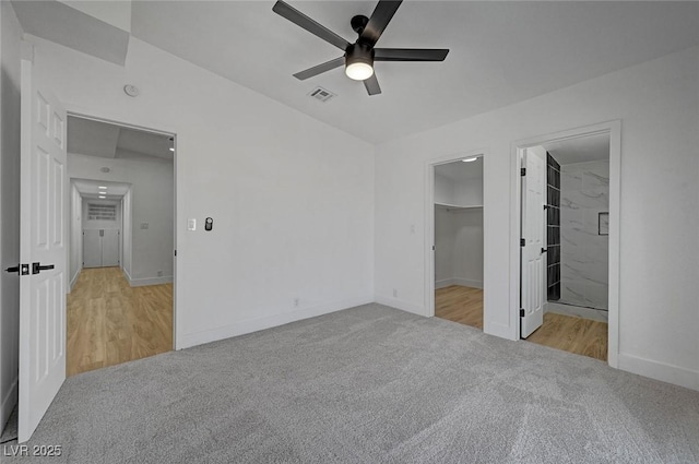 unfurnished bedroom featuring carpet floors, a walk in closet, visible vents, and baseboards