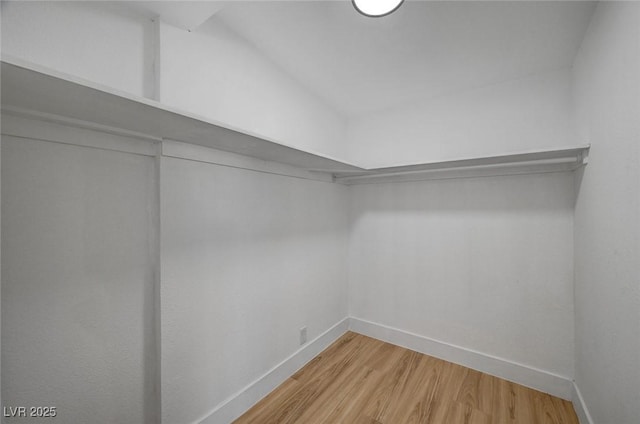 walk in closet with wood finished floors