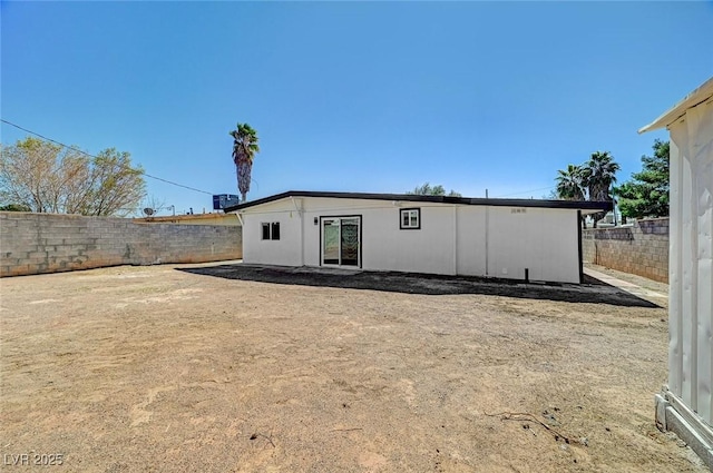 rear view of house with a fenced backyard