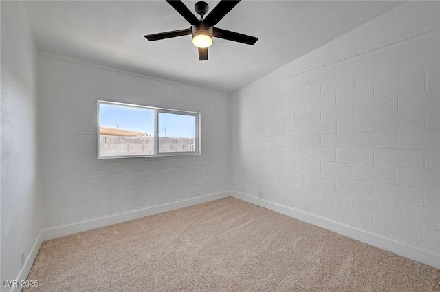 carpeted empty room featuring vaulted ceiling, ceiling fan, and baseboards