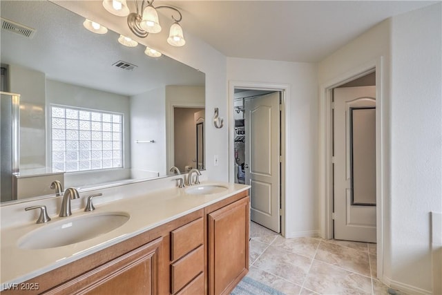 bathroom featuring double vanity, visible vents, and a sink