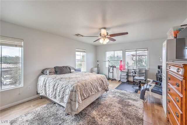 bedroom with visible vents, ceiling fan, light wood-style flooring, and baseboards