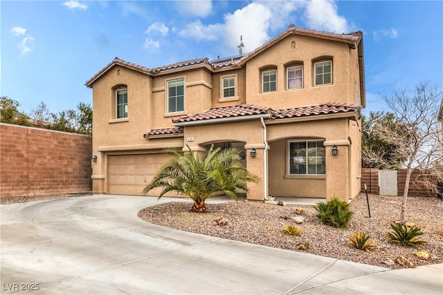 mediterranean / spanish-style house with driveway, an attached garage, fence, and stucco siding