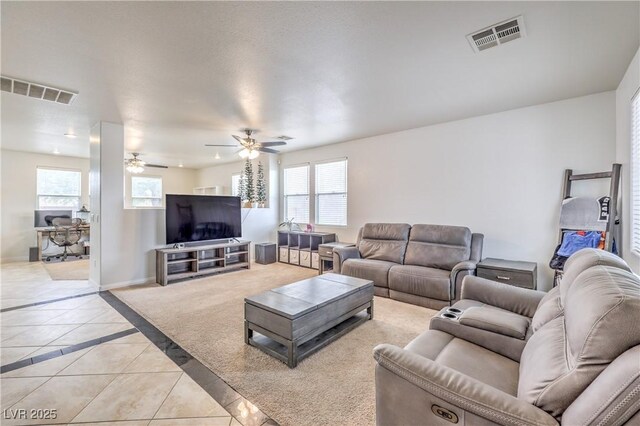 living room with light tile patterned floors, baseboards, visible vents, and a ceiling fan