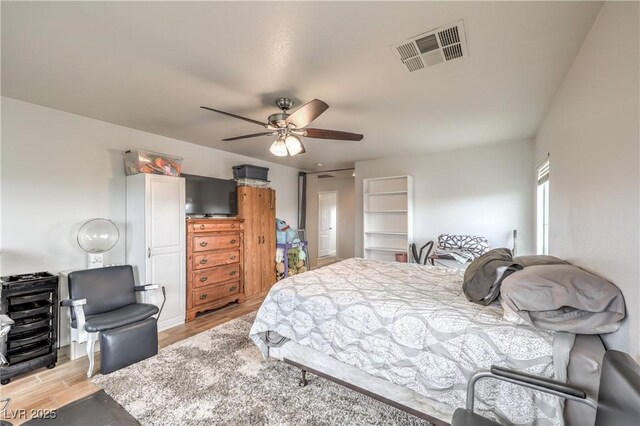 bedroom with a ceiling fan, visible vents, and light wood-style floors