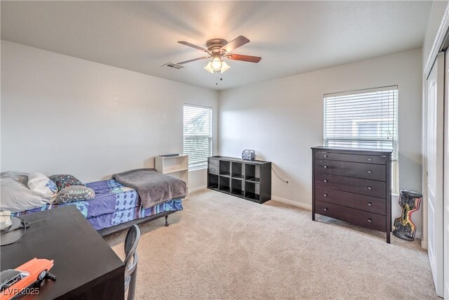 carpeted bedroom with ceiling fan, a closet, visible vents, and baseboards