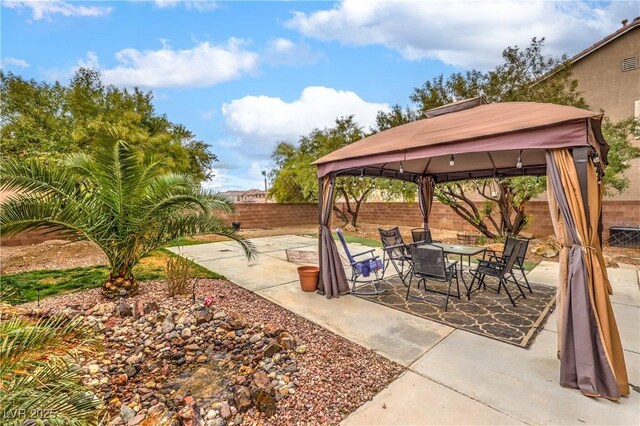 view of patio / terrace featuring a fenced backyard, outdoor dining area, and a gazebo