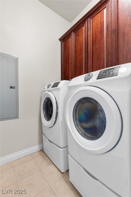 laundry room featuring cabinet space, light tile patterned floors, electric panel, baseboards, and washing machine and dryer