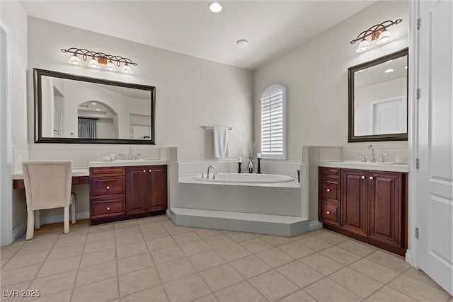 bathroom featuring a garden tub, two vanities, a sink, and tile patterned flooring