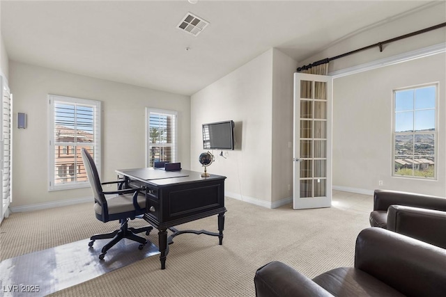 home office featuring visible vents, vaulted ceiling, light carpet, and baseboards