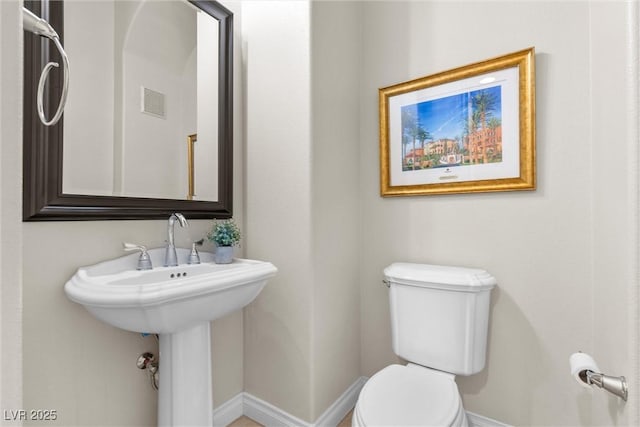 bathroom with baseboards, visible vents, and toilet