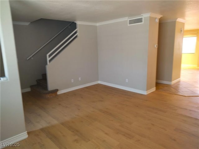 interior space with light wood-type flooring, stairway, visible vents, and crown molding