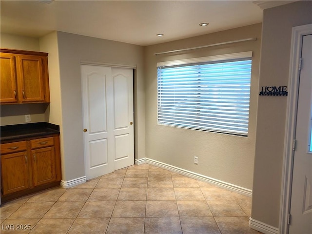 interior space with light tile patterned floors, recessed lighting, and baseboards