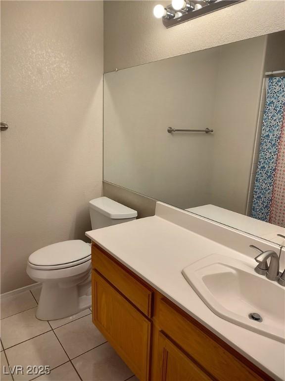 bathroom featuring vanity, a shower with shower curtain, tile patterned flooring, and toilet