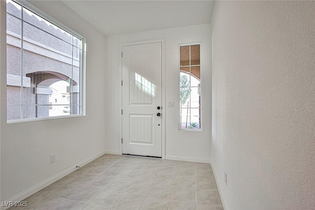 entryway featuring light tile patterned flooring and baseboards