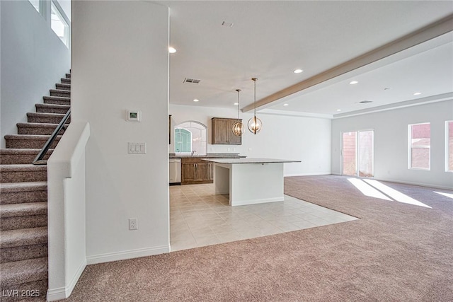 kitchen featuring open floor plan, light colored carpet, and dishwasher