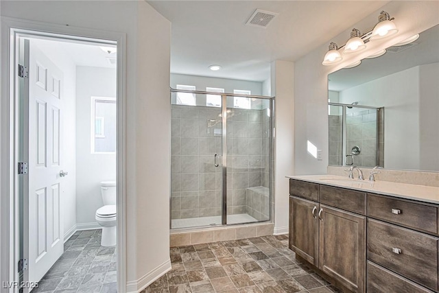 bathroom with toilet, vanity, visible vents, baseboards, and a shower stall