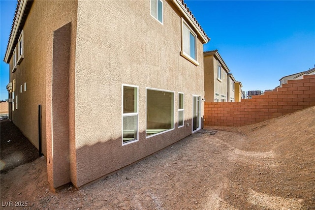 view of home's exterior with fence and stucco siding