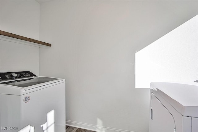 laundry area featuring laundry area, baseboards, washing machine and clothes dryer, and wood finished floors