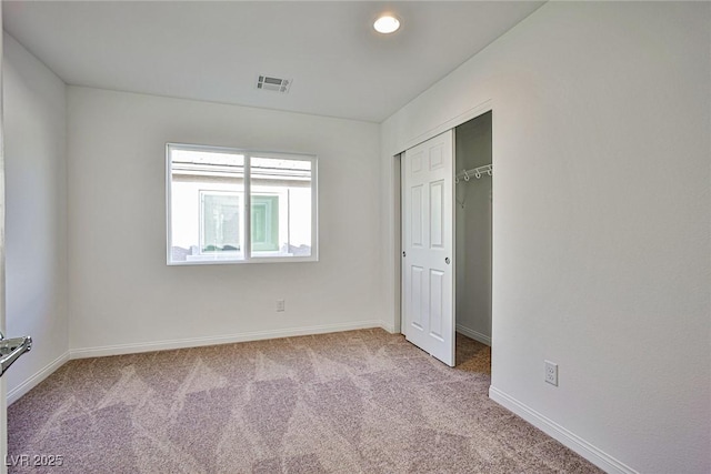 unfurnished bedroom with carpet floors, a closet, visible vents, and baseboards