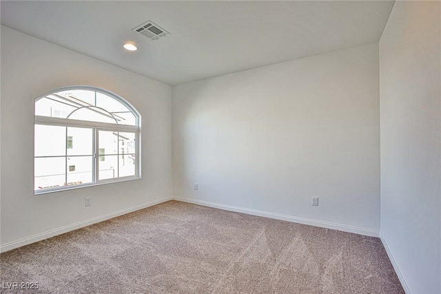 carpeted empty room with visible vents, baseboards, and recessed lighting