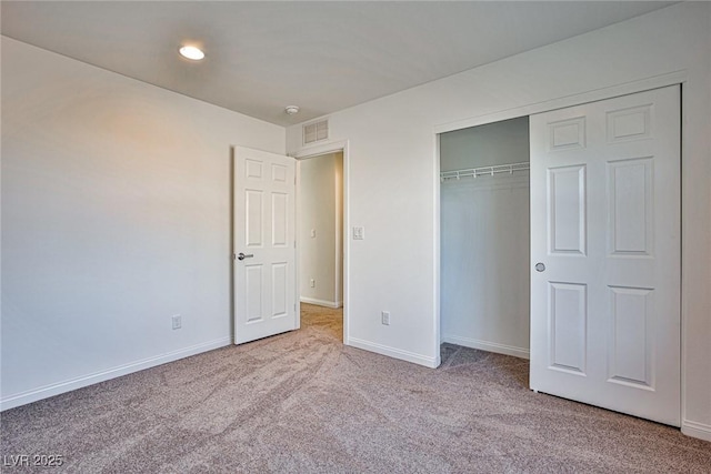 unfurnished bedroom featuring a closet, carpet flooring, visible vents, and baseboards