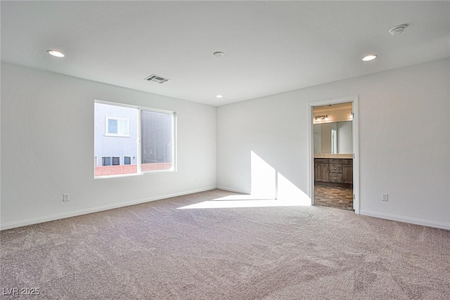 spare room with carpet, visible vents, baseboards, and recessed lighting