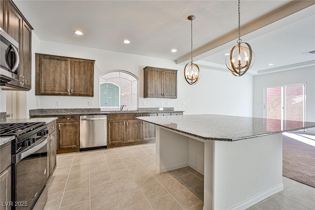 kitchen featuring stone counters, stainless steel appliances, beamed ceiling, and recessed lighting