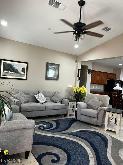 living area featuring light tile patterned floors, ceiling fan, lofted ceiling, and visible vents