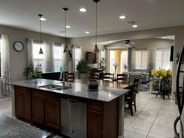 kitchen featuring open floor plan, visible vents, a sink, and light tile patterned floors