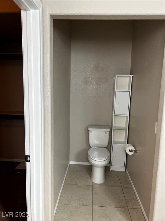 bathroom featuring baseboards, toilet, and tile patterned floors