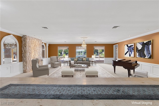 living area featuring ornamental molding, wainscoting, visible vents, and a decorative wall