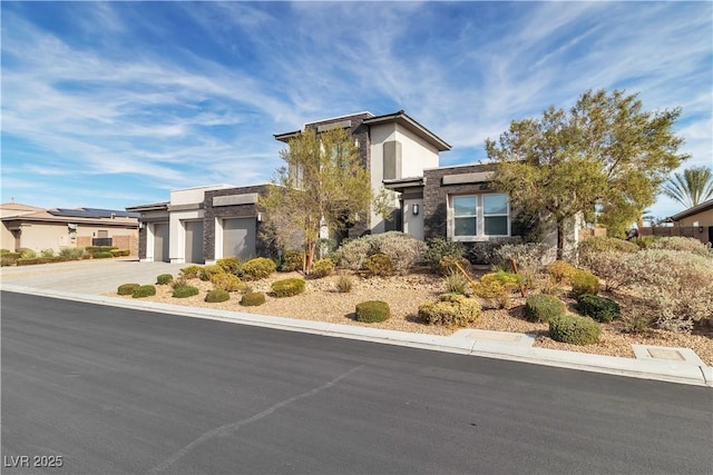 view of front facade featuring a garage, driveway, and stucco siding