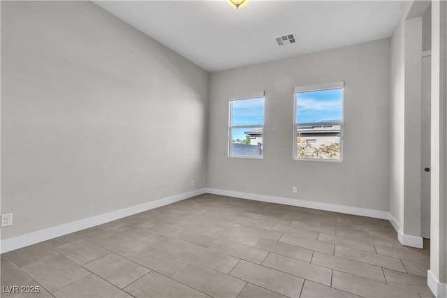 spare room with baseboards and visible vents