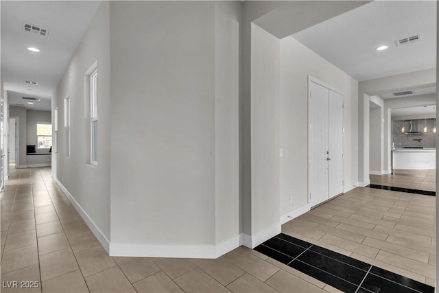 hallway with recessed lighting, visible vents, and baseboards