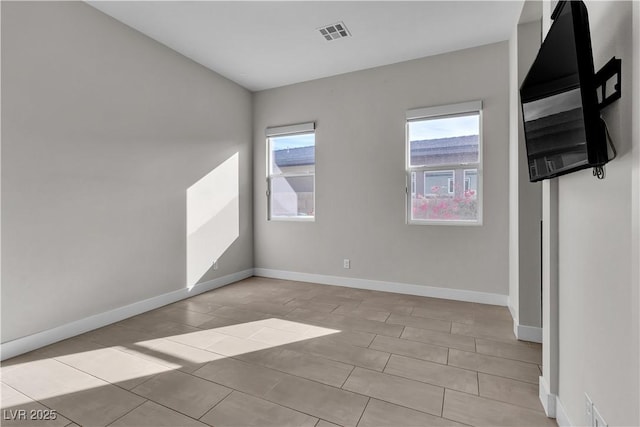 unfurnished room with baseboards and visible vents